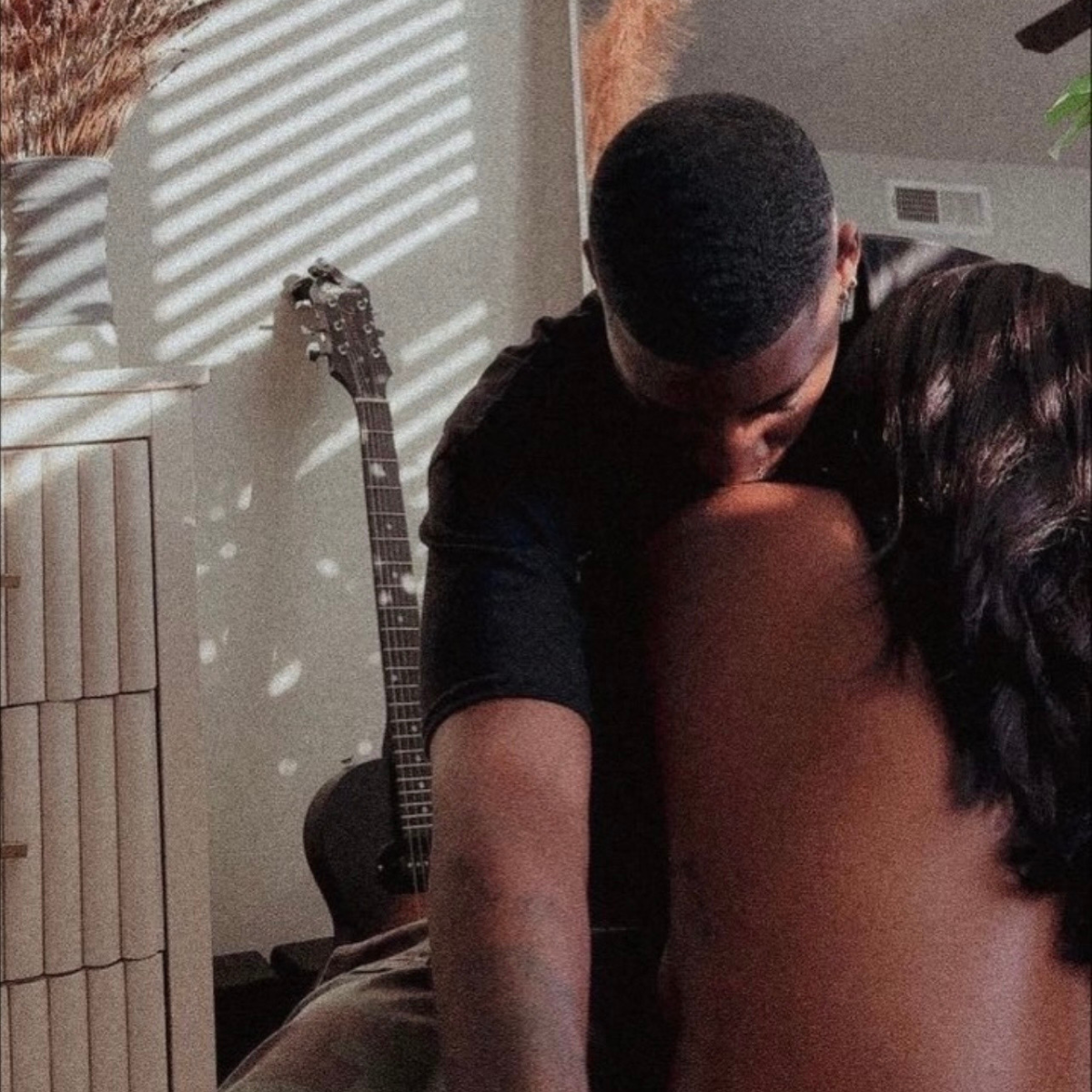 Two people embracing in a room with a guitar leaning against a wall.    Discover pleasure products in Trinidad and Tobago from Belle Exotics, including couple toys, lubricants, lingerie, and beginner-friendly adult products.