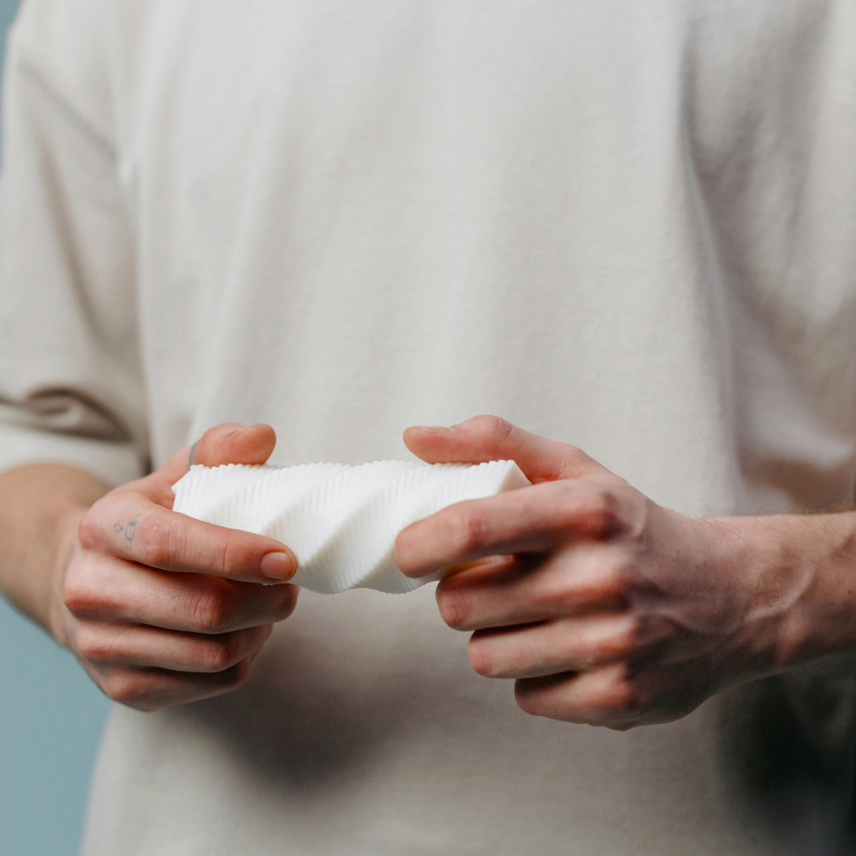 Person holding a white MALE MASSAGER with a neutral background. Discover pleasure products in Trinidad and Tobago from Belle Exotics, including couple toys, lubricants, lingerie, and beginner-friendly adult products.