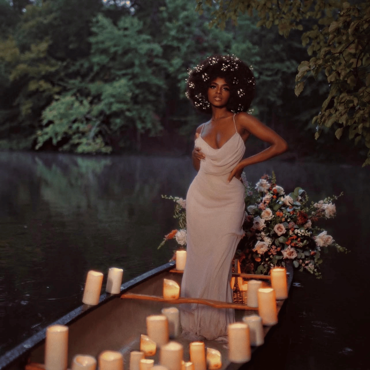 A woman stands in a canoe on a lake surrounded by trees, wearing a sleeveless draped off-white gown. The canoe is lit with many candles, and a floral arrangement sits beside her.Belle Exotics is a discreet adult toy and sexual wellness store in Trinidad and Tobago, offering pleasure products, lubricants, lingerie, couple toys, self-love essentials, and intimacy accessories for private online and in-store shopping.   Belle Exotics offers discreet adult toys.